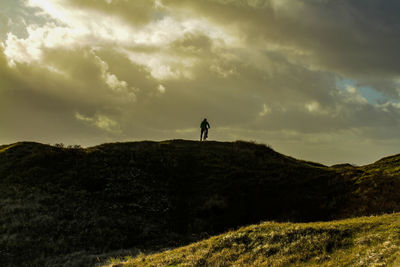 Silhouette man standing on land against sky