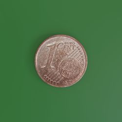 Close-up of coins against green background