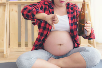 Midsection of woman sitting at home