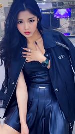 Portrait of young woman standing against building