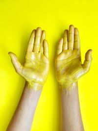 Close-up of hand holding yellow over white background