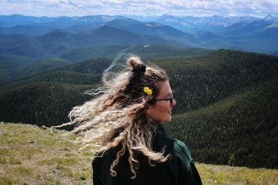 Portrait of young woman against mountains