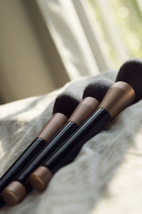 Close-up of make-up brushes on bed