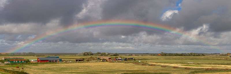 Panoramic view of rainbow over land against sky