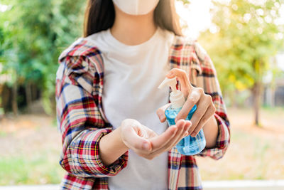 Midsection of woman holding camera