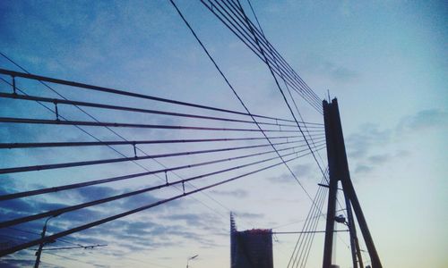 Low angle view of electricity pylon against blue sky