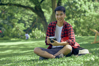 Full length of young man sitting on grass