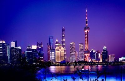 Illuminated buildings against sky at night