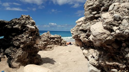 Rock formation on beach against sky