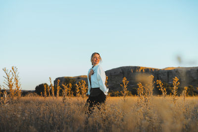 Woman standing on field against clear sky