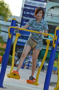 Woman standing on outdoors play equipment in park