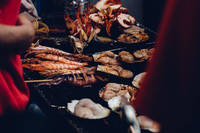 Midsection of person selling seafood at market