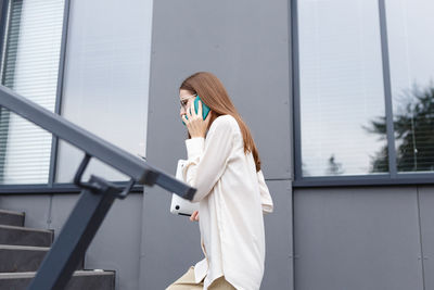 Young stylish white woman talking on a smartphone