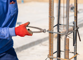 Workers tie wire to rebar to pour concrete poles in building construction site.