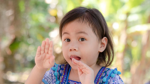 Cute baby asian girl, preschooler child showing tongue. children with funny expressions on her face.