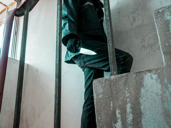 Low section of man standing on metal