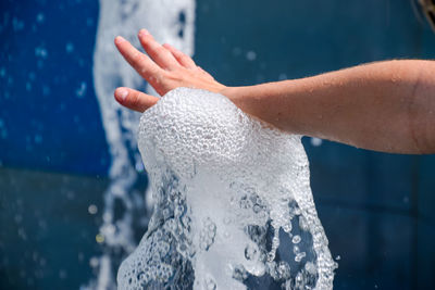 Cropped hand touching water in fountain