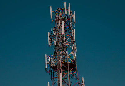 Low angle view of communications tower against clear blue sky