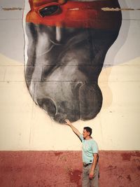 Full length of man standing against wall