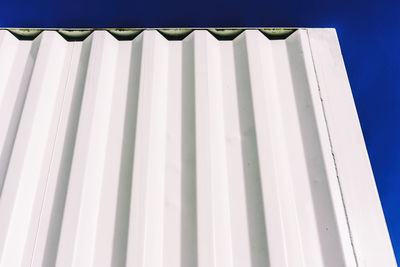 Low angle view of shipping container against clear blue sky