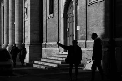 Silhouette people walking outside building