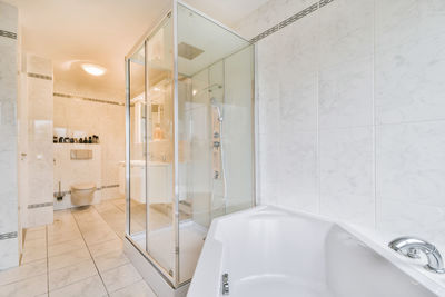 Bathtub against shower cubicle in modern bathroom