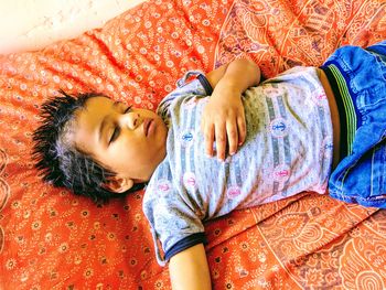 High angle view of boy sleeping on bed at home