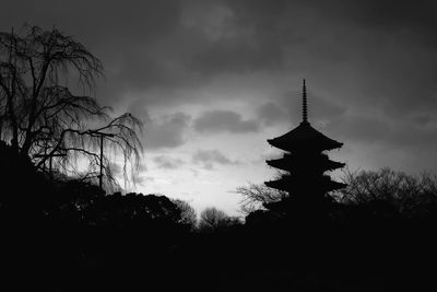 Silhouette of trees against cloudy sky