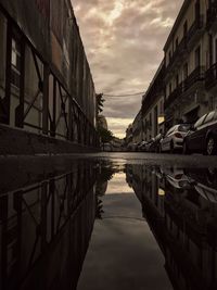 Canal amidst buildings in city against sky