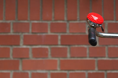 Cropped image of bicycle bell against brick wall