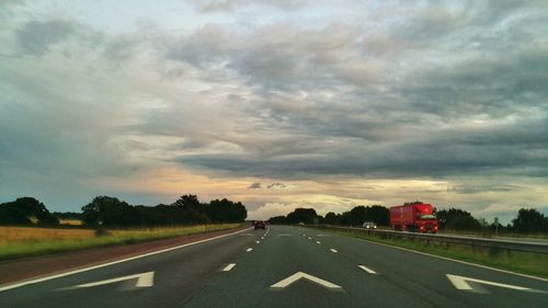 Empty road against cloudy sky