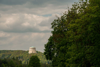 Low angle view of trees and plants against sky with the befreiungshalle in the background. 