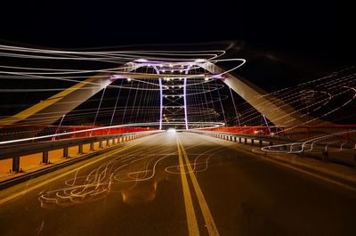 Light trails on street against sky at night