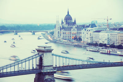 Bridge over river against buildings in city