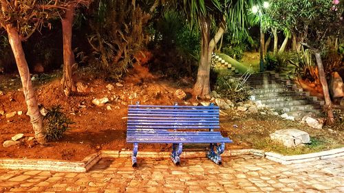 Empty bench in park by lake