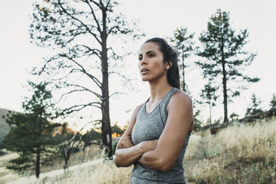 Sportswoman with arms crossed standing on field