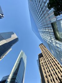 Low angle view of modern buildings against blue sky