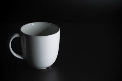 Close-up of coffee cup against black background