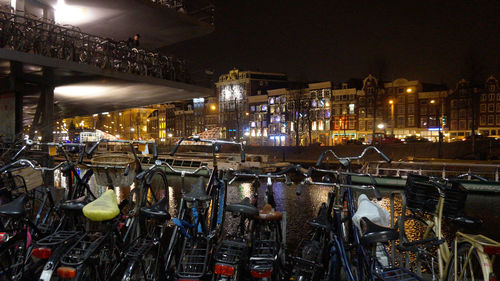 Illuminated buildings by street against sky at night