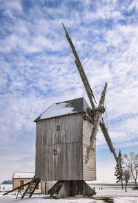 Traditional windmill on field against sky