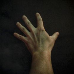 Cropped image of hand against black background