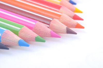 Close-up of colorful colored pencils over white background