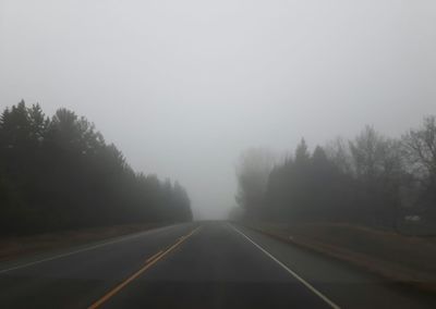 Road amidst trees against sky