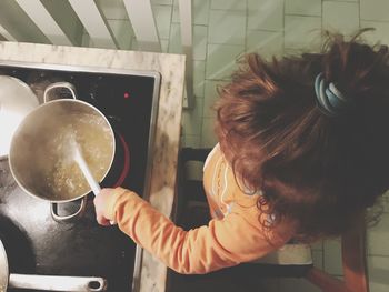 High angle view of girl preparing food at kitchen