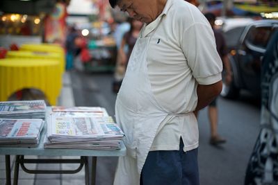 Midsection of man wearing shoes in city