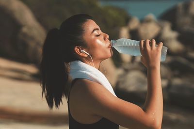 Side view of woman drinking water