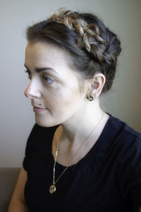 Close-up portrait of young woman against wall