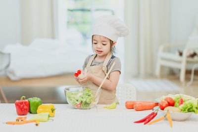 Cute girl preparing food on table at home