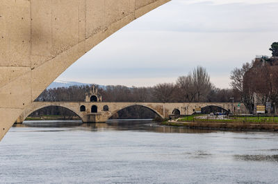 Arch bridge over river against sky