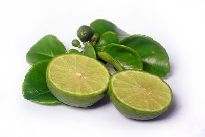 Close-up of green fruits against white background